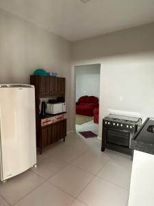 Il comprend une cuisine équipée d'un réfrigérateur et d'un canapé rouge. dans l'établissement Ary Beach / Barra Grande -Pi, à Cajueiro
