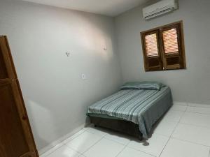 - une petite chambre avec un lit et une fenêtre dans l'établissement Ary Beach / Barra Grande -Pi, à Cajueiro