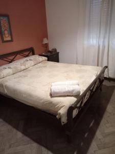 Una cama con toallas en un dormitorio en La casita de Calamuchita en Los Reartes