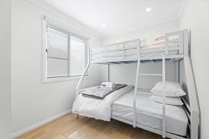 a bedroom with a bunk bed and a window at Barlings Beach Holiday Park in Tomakin