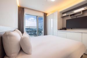 a bedroom with a large white bed with a large window at Skytop Hotel Incheon Airport in Incheon +18 photos