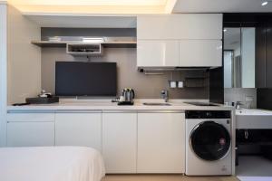 a kitchen with a washing machine and a sink at Skytop Hotel Incheon Airport in Incheon