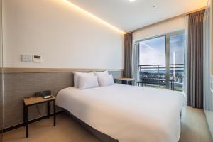 a hotel room with a large bed and a window at Skytop Hotel Incheon Airport in Incheon