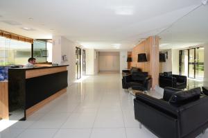 a man sitting at a bar in a hospital lobby at ótima localizacao e perto de tudo in São José