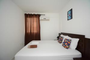 a bedroom with a bed with white sheets and pillows at ótima localizacao e perto de tudo in São José +21 photos