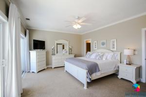 a white bedroom with a bed and a tv at Beachfront Oasis At Tybee Island in Tybee Island