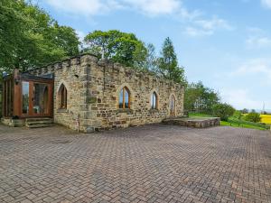 a stone building on a brick road at The Water Castle in Wall Houses