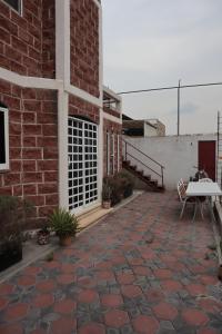 een bakstenen gebouw met een patio met een tafel en een bank bij KOLSA in Santa María Tonantzintla