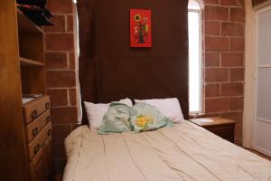 een slaapkamer met een bed met 2 kussens erop bij KOLSA in Santa María Tonantzintla