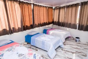 2 Betten in einem Zimmer mit Vorhängen in der Unterkunft Uai Só Hostel in Belo Horizonte
