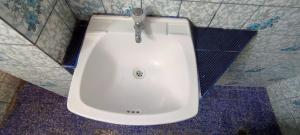 lavabo blanco en un baño con azulejos azules y blancos en Hostal Reyna en Lima