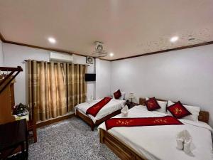 ein Hotelzimmer mit 2 Betten und einem Fenster in der Unterkunft Luang Prabang Rosie Place in Luang Prabang
