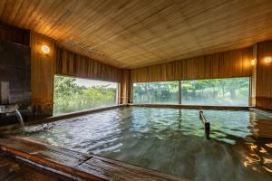 duży basen z wodą w pokoju z oknami w obiekcie KAMENOI HOTEL Aomori Makado w mieście Noheji