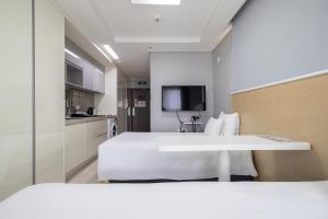 ein Hotelzimmer mit Bett und Küche in der Unterkunft GL City Hotel Incheon Airport in Incheon
