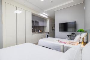a hotel room with two beds and a television at GL City Hotel Incheon Airport in Incheon