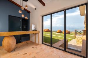 a tasting room with a view of a field through sliding glass doors at Hotel Qvevrebi in Tʼelavi