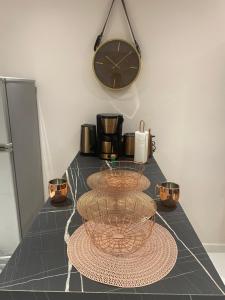 une table avec une horloge sur le mur et une horloge dans l'établissement Au PETIT NONI, au Gosier