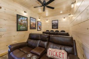 a leather couch in a room with wooden walls at Huny Bear Lodge in Pigeon Forge