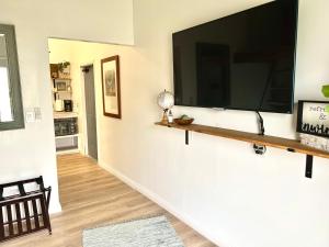 a living room with a large flat screen tv on a wall at Hale ‘Aina (Country Cottage) in Keaau