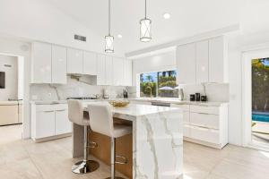a kitchen with white cabinets and a marble counter top at Chateau Monroe - Walk to dwtn Palm Springs in Palm Springs