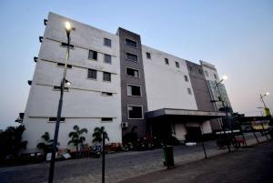 un grand bâtiment blanc avec un éclairage de rue devant lui dans l'établissement OYO Flagship Bengal Inn, à Sānkrāil