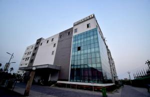 um grande edifício com janelas de vidro numa rua em OYO Flagship Bengal Inn em Sānkrāil