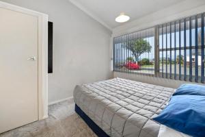 a bedroom with a bed and a large window at Jack & Di's Lakefront Motel in Rotorua