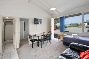 a living room with a couch and a table and chairs at Jack & Di's Lakefront Motel in Rotorua