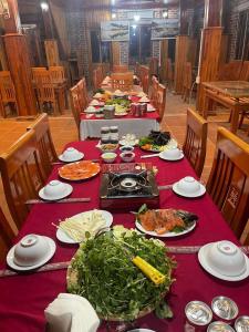 una mesa larga con platos de comida. en Cao nguyên, en Mộc Châu