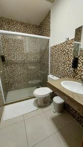 a bathroom with a toilet and a shower and a sink at Itacuruçá Inn in Itacuruçá