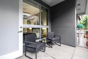 eine Terrasse mit Stühlen und einem Tisch vor einem Gebäude in der Unterkunft Brand New WeHo Luxury Apartment in Los Angeles