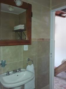a bathroom with a sink and a mirror at POSADA LAS MARGARITAS in Santa Rosa de Calamuchita