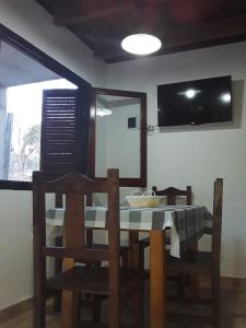 uma sala de jantar com uma mesa, cadeiras e um espelho em POSADA LAS MARGARITAS em Santa Rosa de Calamuchita