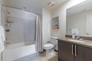 a bathroom with a tub and a toilet and a sink at New WeHo Luxury Apartment in Los Angeles
