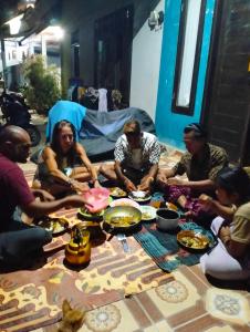 a group of people sitting around a table eating food at T&T Homestay in Kuta Lombok