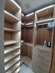 einen begehbaren Kleiderschrank mit Holzregalen und einem Spiegel in der Unterkunft Deluxe_4to Floor_1BR_POOL_GYM in Santo Domingo