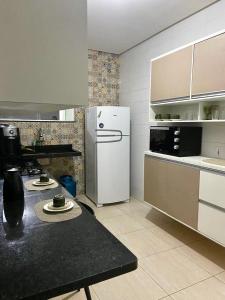 een keuken met een koelkast en een tafel. bij Linda Casa com piscina e totalmente climatizada Airbn b in Petrolina
