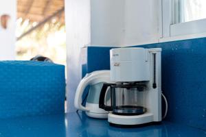 a coffee maker sitting on a counter next to a window at Azul Zambales Beachfront House & River Cottages EXCLUSIVE in Cabangan