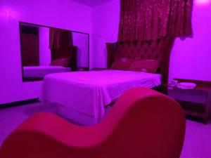 a purple room with a bed and a mirror at Hostal Reyna in Lima +3 photos