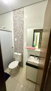 a bathroom with a toilet and a sink and a mirror at Linda Casa com piscina e totalmente climatizada Airbn b in Petrolina