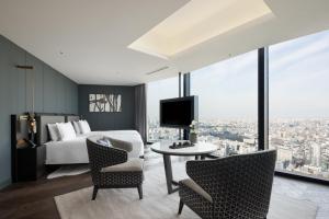 Habitación de hotel con cama, mesa y sillas en BELLUSTAR TOKYO, A Pan Pacific Hotel en Tokio