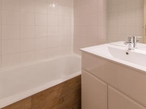 a white bathroom with a sink and a bath tub at Appartement La Plagne Montalbert , 2 pièces, 5 personnes - FR-1-181-2723 in Aime-La Plagne