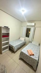 two beds in a small room with a window at Linda Casa com piscina e totalmente climatizada Airbn b in Petrolina