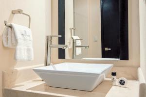 um lavatório branco sentado num balcão na casa de banho em Sendero Hotel em Actopan