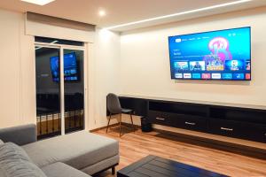 Sendero Hotel في Actopan: غرفة معيشة مع أريكة وتلفزيون بشاشة مسطحة