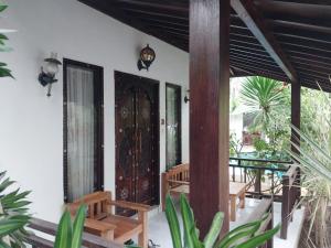 un porche de una casa con puerta de madera en Banana Leaf Resort, en Gili Trawangan