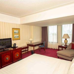 a hotel room with a bed and a desk and a television at Redtop Hotel & Convention Center in Jakarta