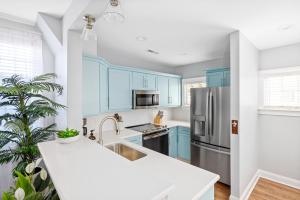 a kitchen with blue cabinets and a stainless steel refrigerator at Hidden Outdoor Oasis - 1 BLOCK TO KING in Charleston