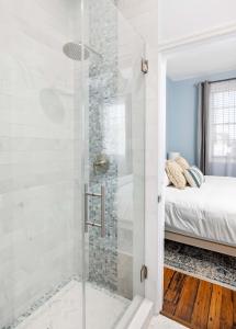 a bathroom with a shower with a glass door at Charming Secluded Courtyard - 1 BLOCK TO KING in Charleston