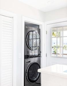 a washer and dryer in a white kitchen at Charming Secluded Courtyard - 1 BLOCK TO KING in Charleston